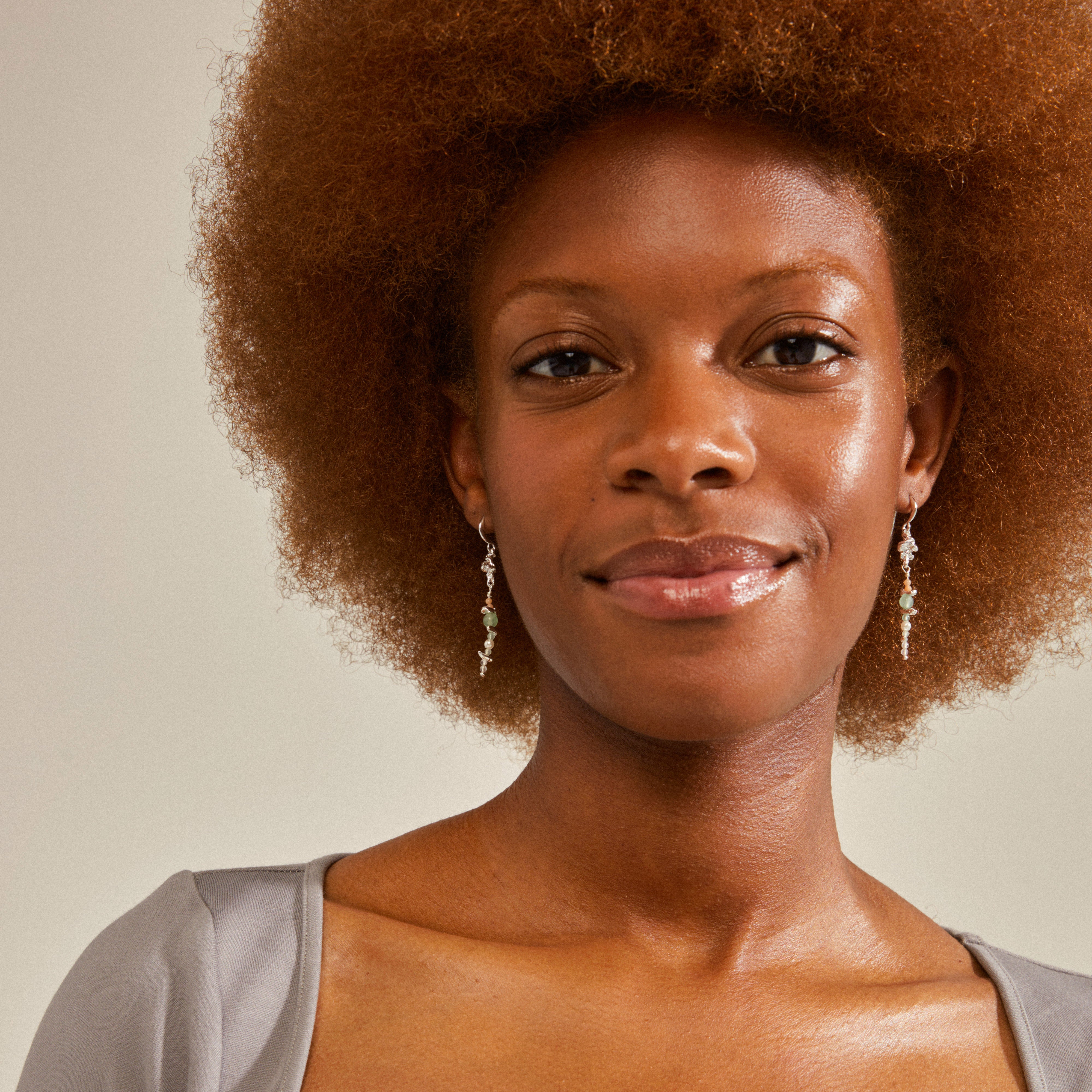 Woman wearing CLOUD earrings by Pilgrim, featuring silver-plated details and dreamy semi-precious stones, showcasing a stylish boho-chic look.