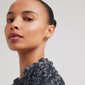 Woman wearing FORCE earrings, 2-in-1 set, gold-plated, featuring ocean-inspired motifs. Highlighting the ruffled shirt and ponytail. Perfect for sharing and expressing love.