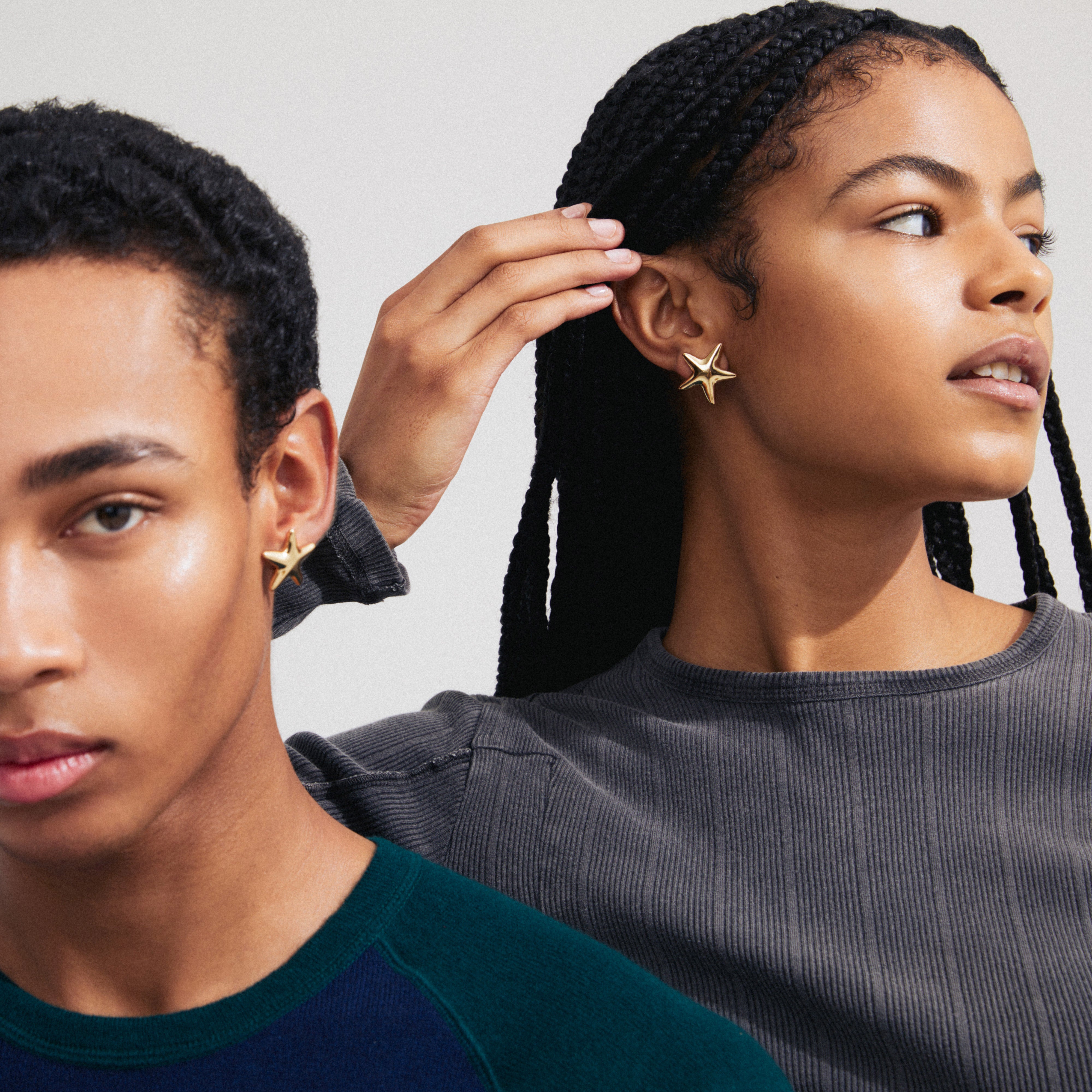 FORCE gold-plated earrings feature large, eye-catching starfish shapes, perfect for a bohemian summer look. Seen worn by a woman with braided hair.