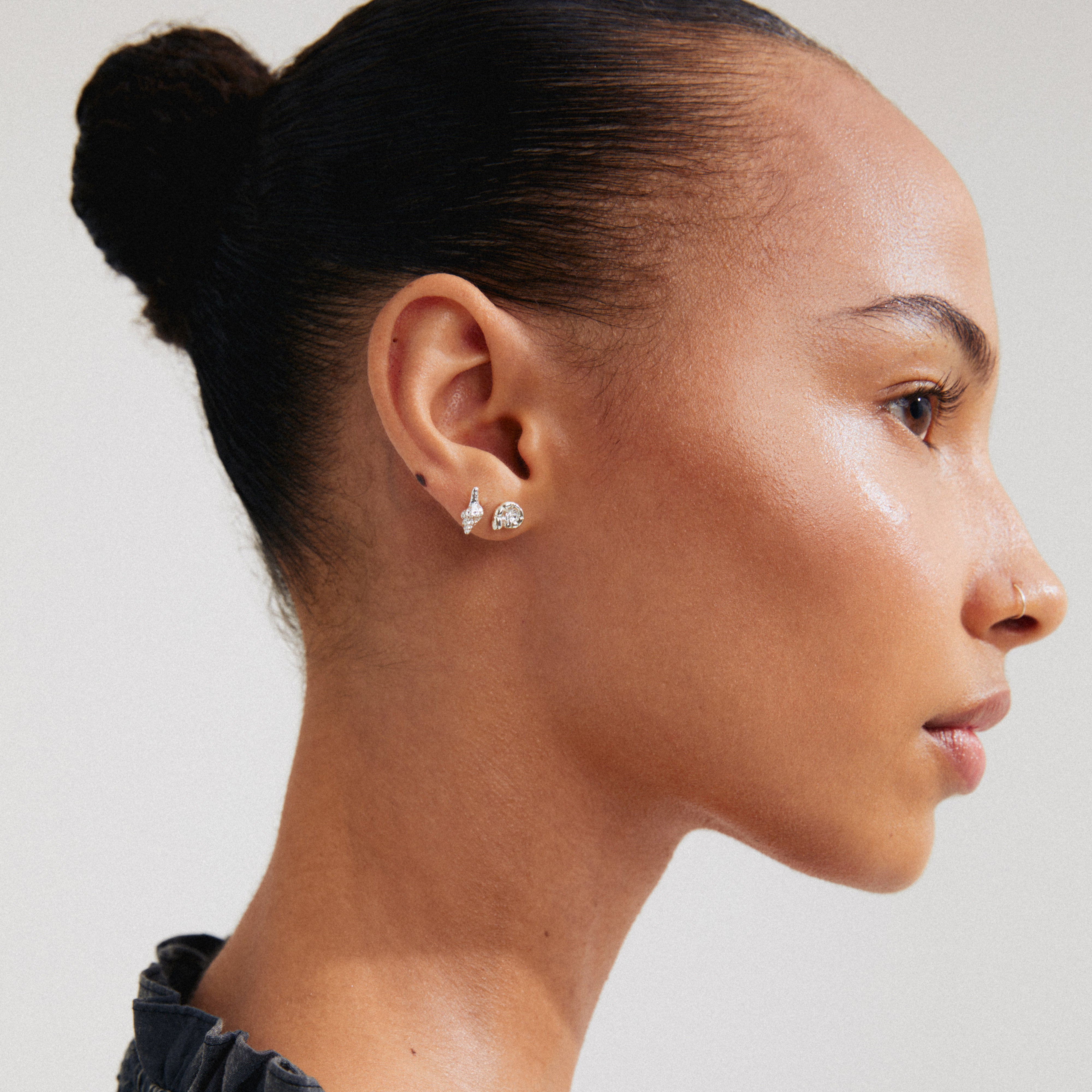 Silver-plated FORCE earrings, 2-in-1 set, featuring ocean-inspired motifs, worn by a woman with a bun. Made from 89% recycled material.