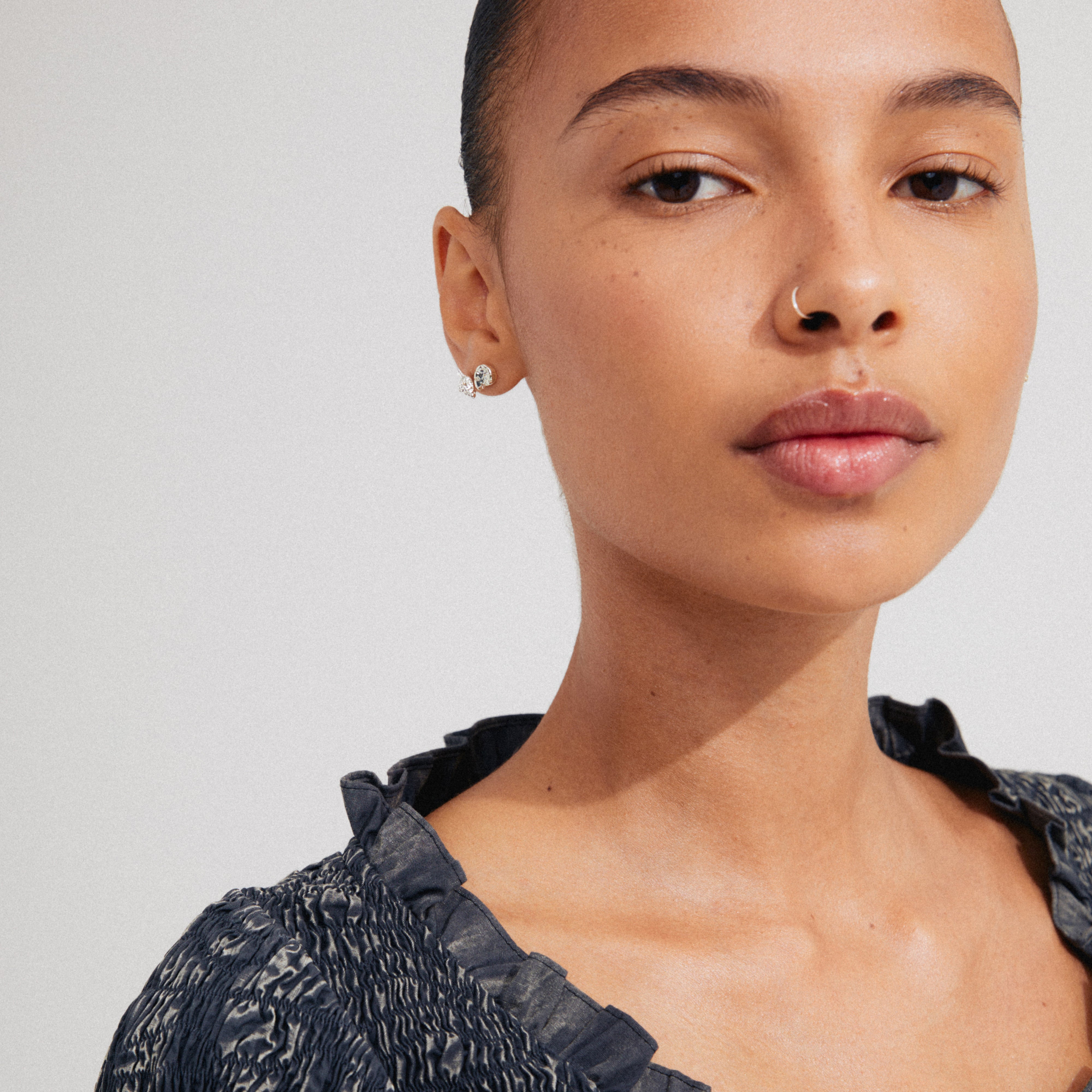 Close-up of a woman wearing FORCE earrings, 2-in-1 set, silver-plated, featuring ocean-inspired motifs, emphasizing sustainable fashion from Pilgrim.