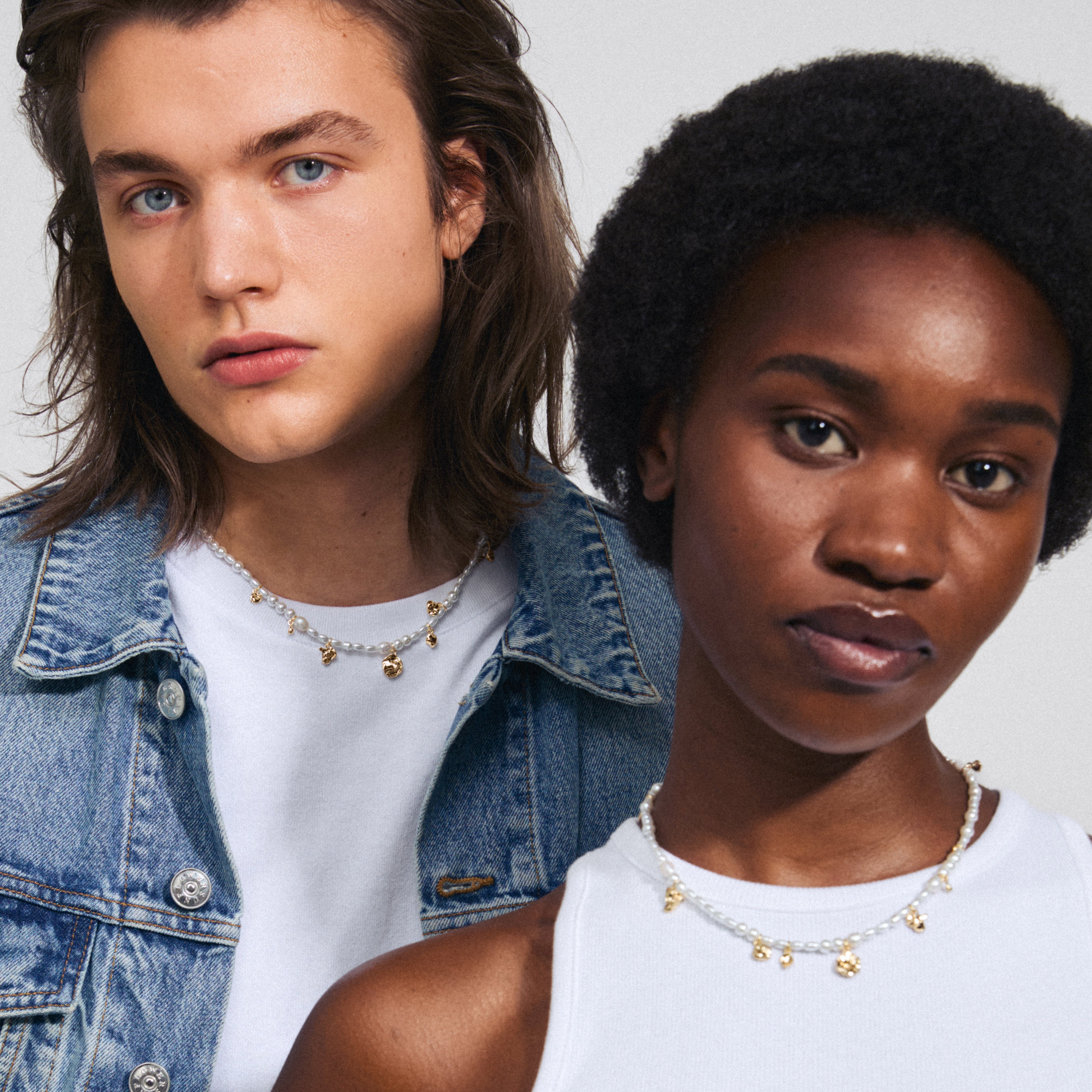 Man and woman wearing the INTENT pearl necklace gold-plated, showcasing freshwater pearls, pearlescent glass beads, and gold-plated organic pendants.
