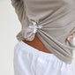 Close-up of DREAM hair-accessory silver-plated flower clamp knotted on a taupe-grey T-shirt, showcasing its versatility as both a brooch and hair accessory.