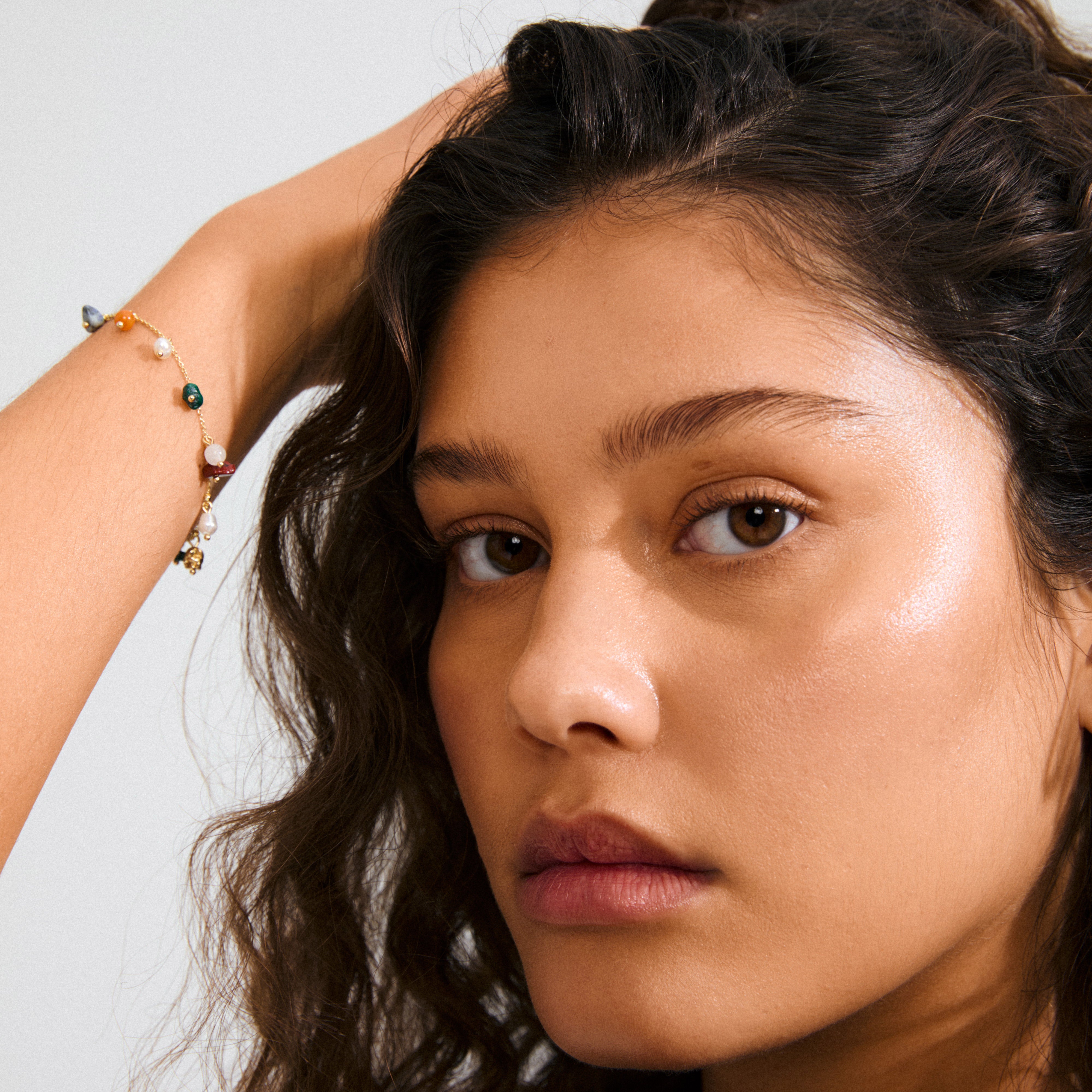 Close-up showing Pilgrim's BETWEEN gold-plated bracelet with vibrant semi-precious stones, adding a luxe boho touch to personal style.
