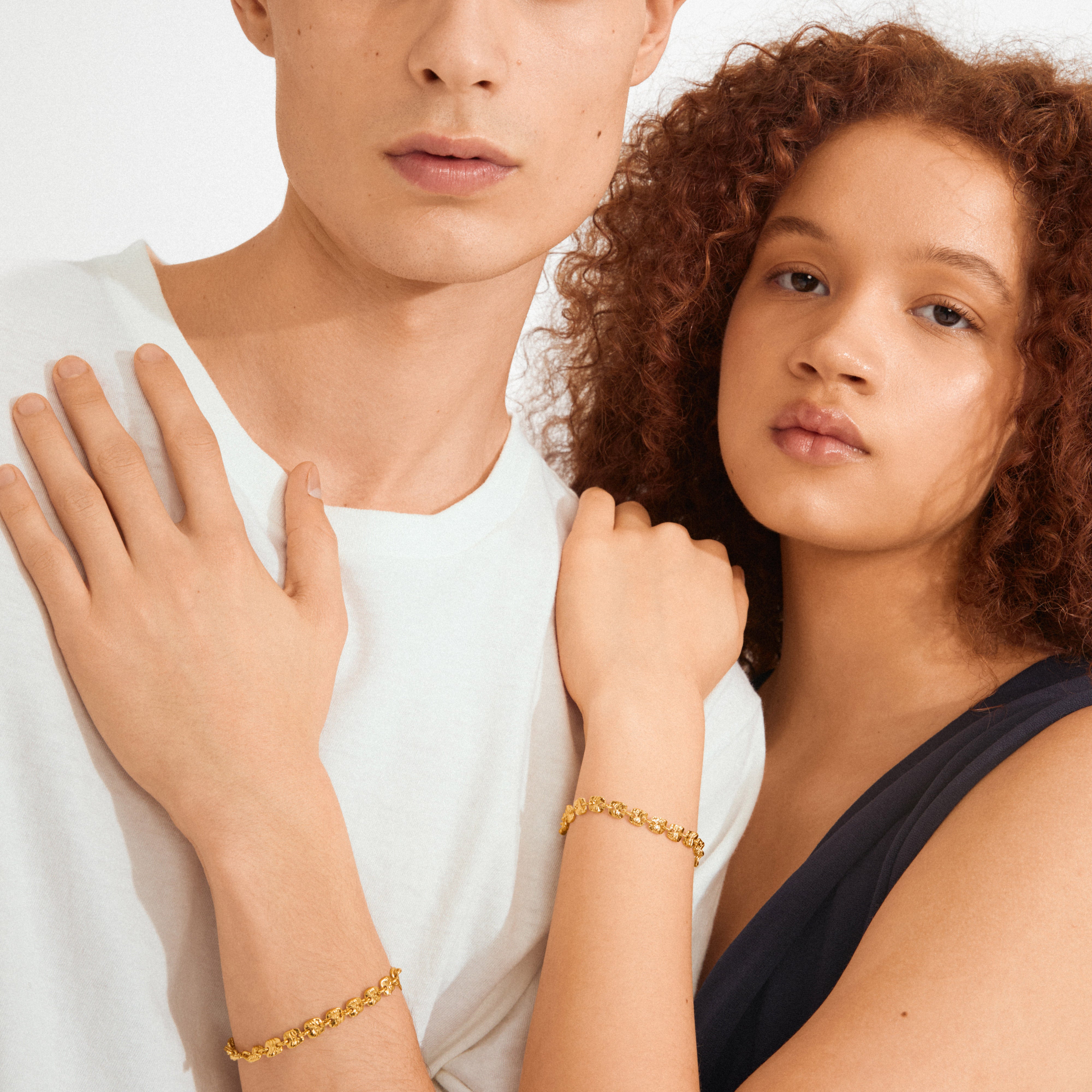 Young man and woman showcase the Pilgrim SENSE gold-plated bracelets, highlighting their delicate, handcrafted style with light-reflecting square coins for a trendy, minimalist look.