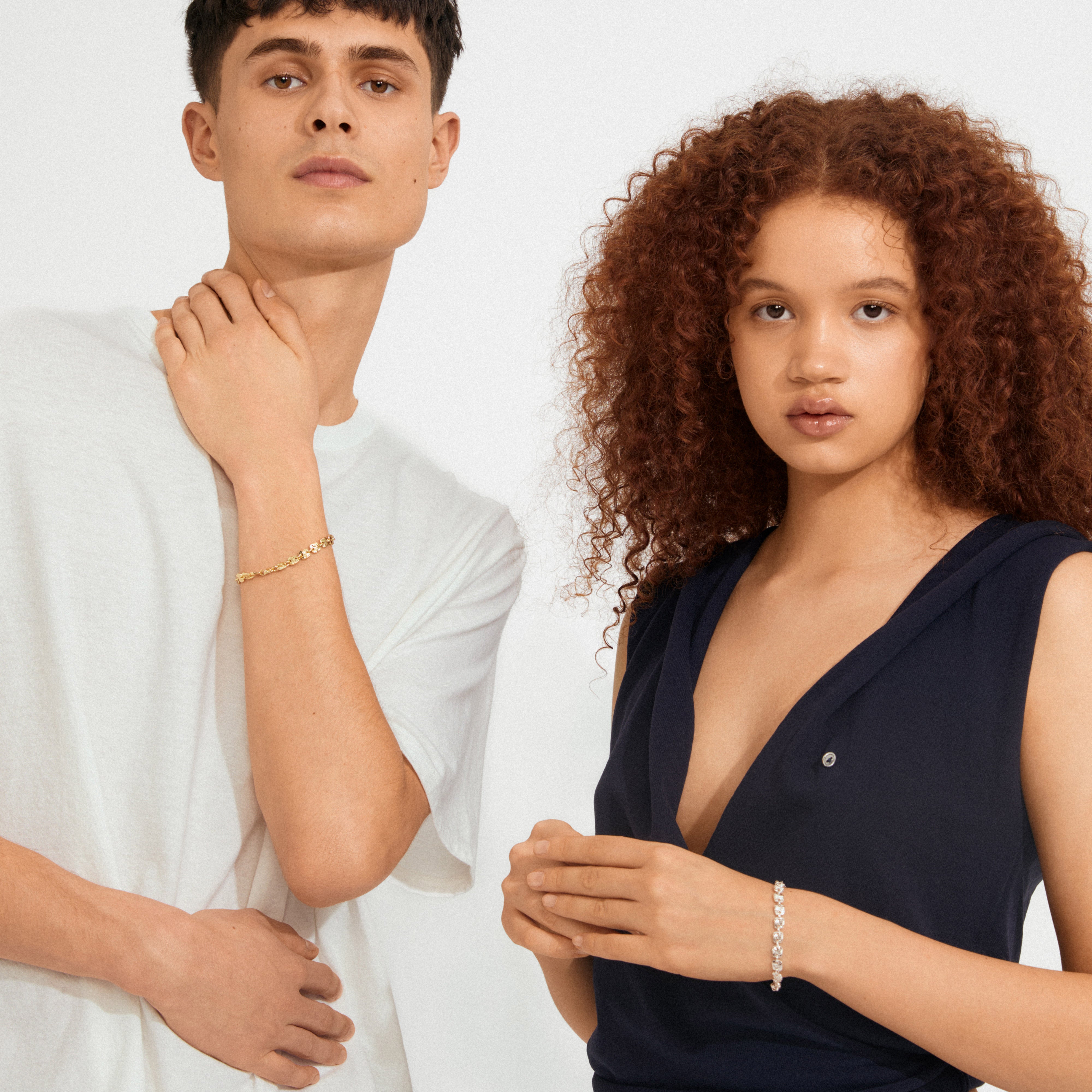 The SENSE bracelet, silver-plated with wavy square coins, adorns a model's wrist, showcasing its delicate, handcrafted vibe alongside other minimalist jewelry.