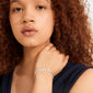 Young woman wearing Pilgrim's SENSE bracelet: a silver-plated, handcrafted piece with wavy, textured square coins, embodying minimalist elegance and Scandinavian style.