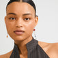 Young woman wearing Pilgrim's SENSE earrings, featuring asymmetrical silver-plated drops with colorful beads, highlighting a boho luxe style.