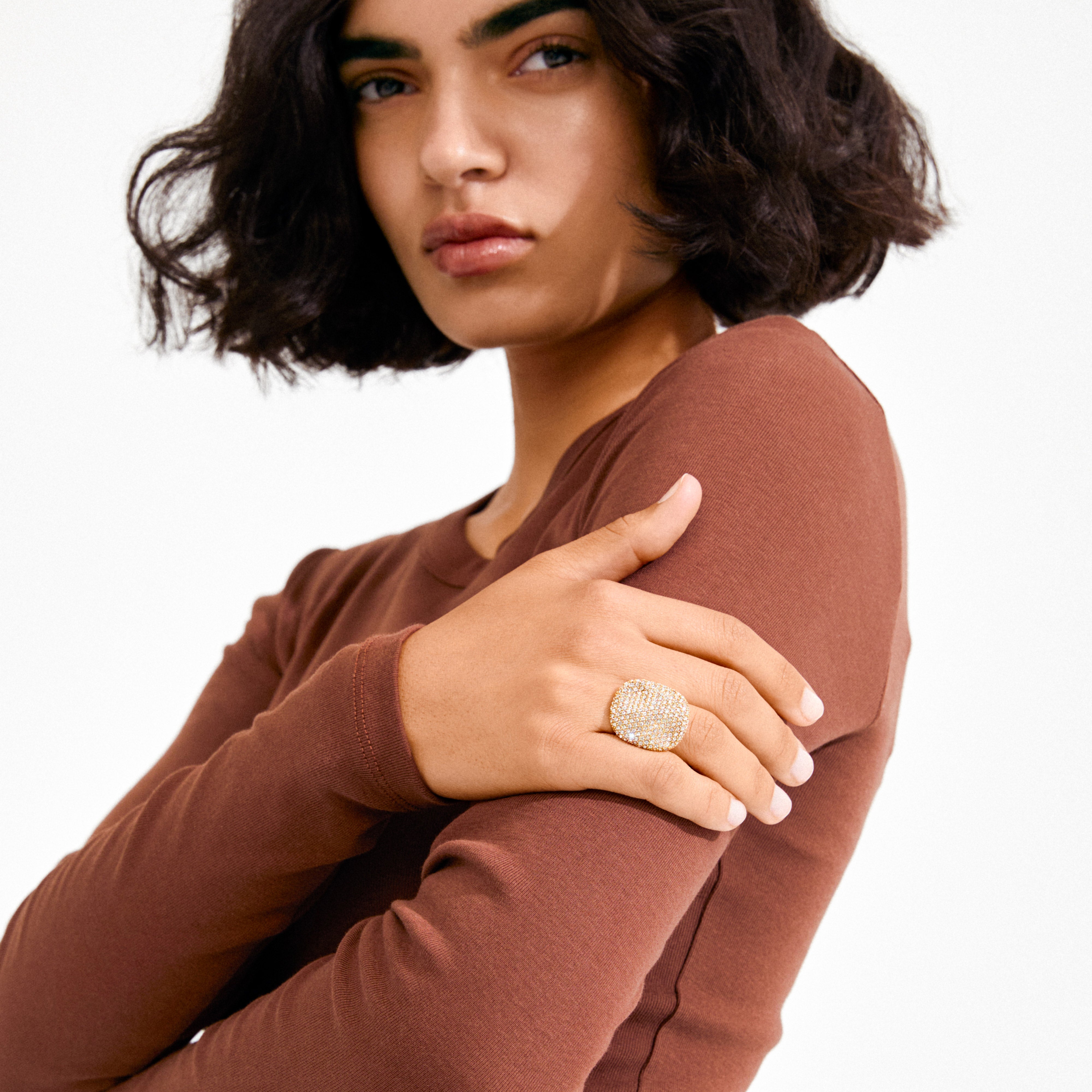 Person wearing the EMBER ring gold-plated by Pilgrim, featuring a bold square design with sparkling crystals, showcasing understated elegance and modern style.