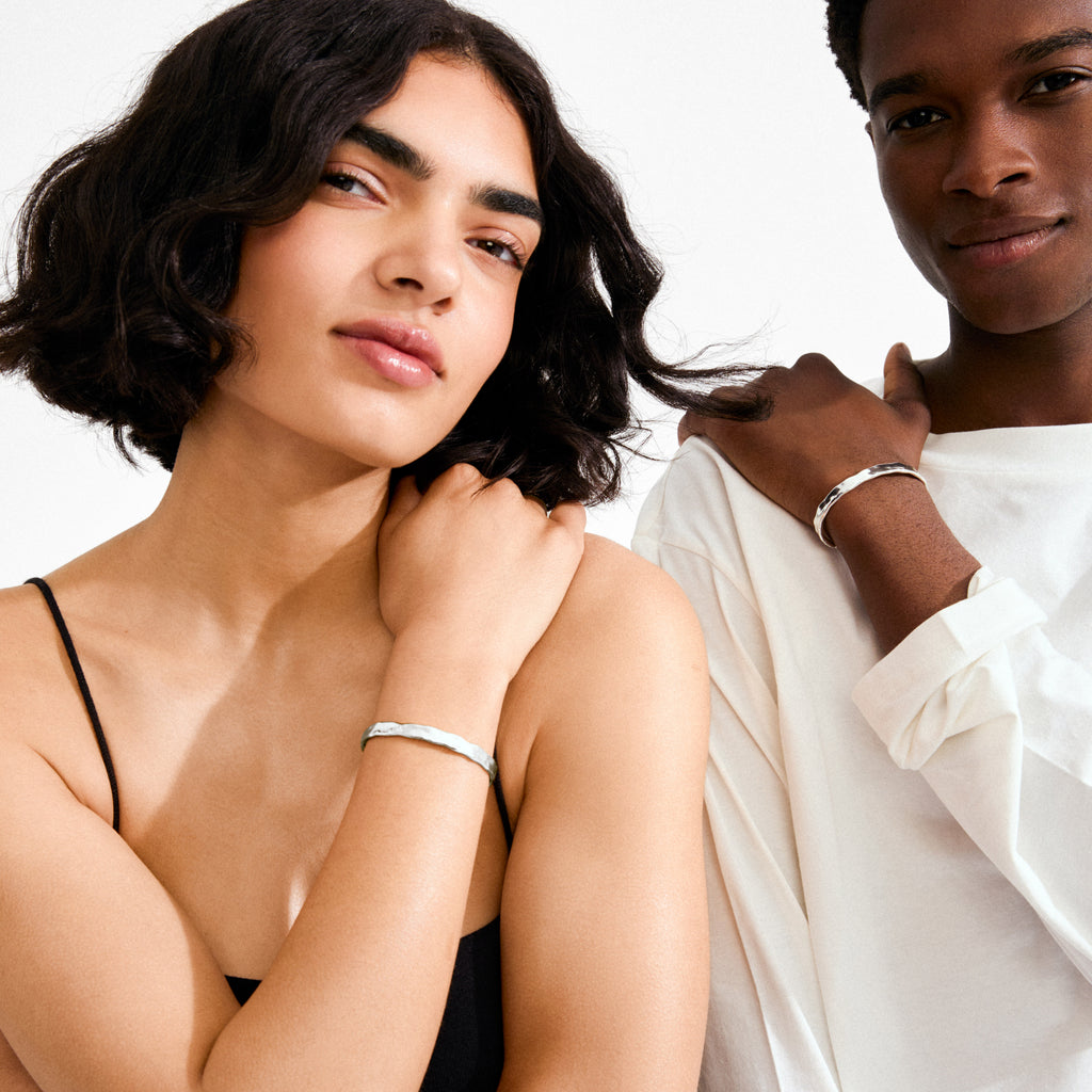 Two models showcase the silver-plated EMBER bracelet, highlighting its sculptural, wavy texture and high-shine finish, embodying Pilgrim's Scandinavian elegance and timeless appeal.