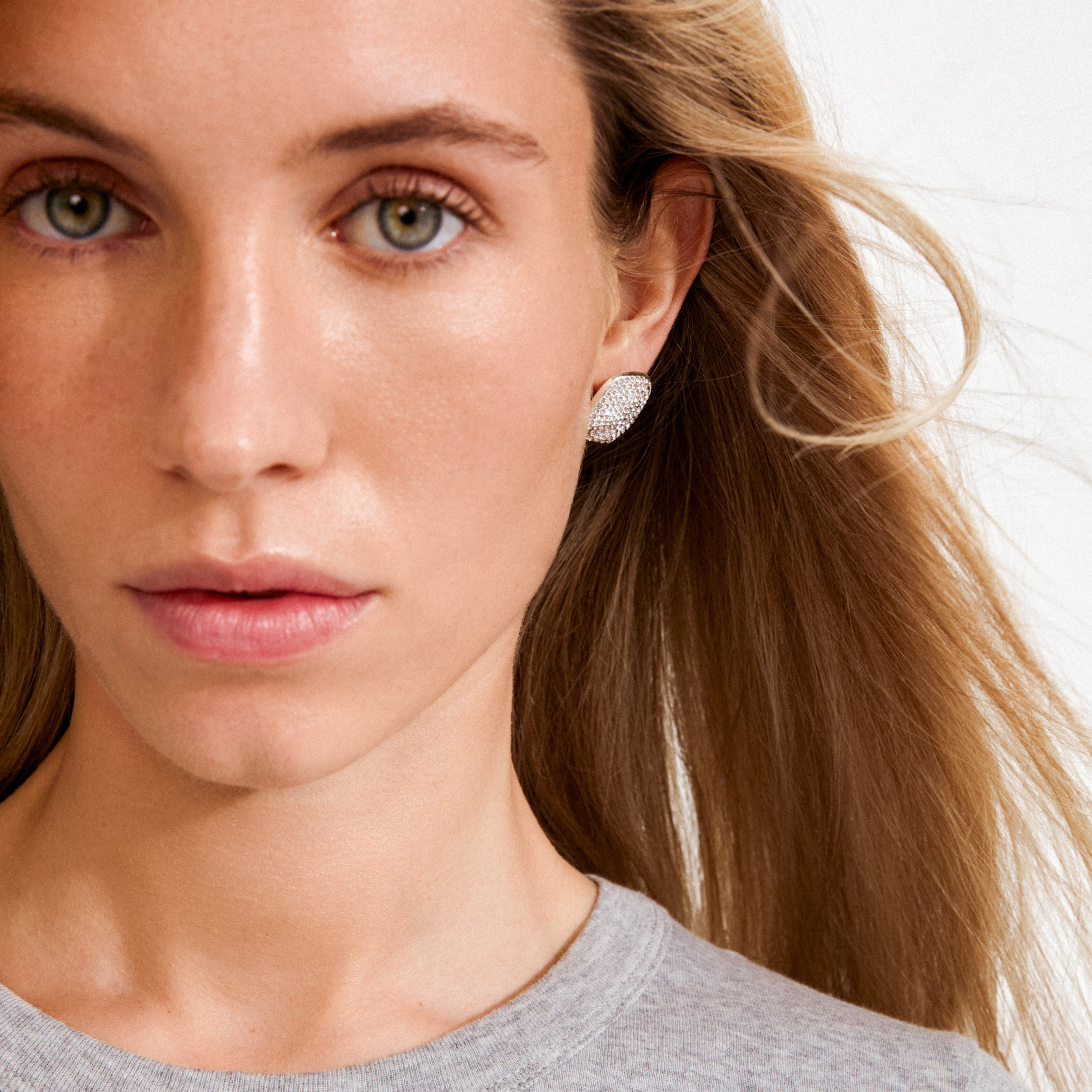 Young woman wearing silver-plated EMBER earrings adorned with sparkling Preciosa crystals, showcasing Pilgrim's blend of timeless elegance and contemporary style.