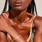 Close-up of a woman wearing the HARPER necklace, featuring intertwined silver-plated rings symbolizing connection, with matching earrings visible.
