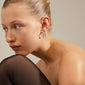Close-up of a woman wearing Pilgrim’s ZION organic-shaped medium hoops, silver-plated, highlighting nature-inspired design elements and boho-chic style.