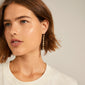 Close-up of THANKFUL long chain earrings gold-plated from Pilgrim, showcasing natural raw shapes and organic design for a classy, down-to-earth vibe.