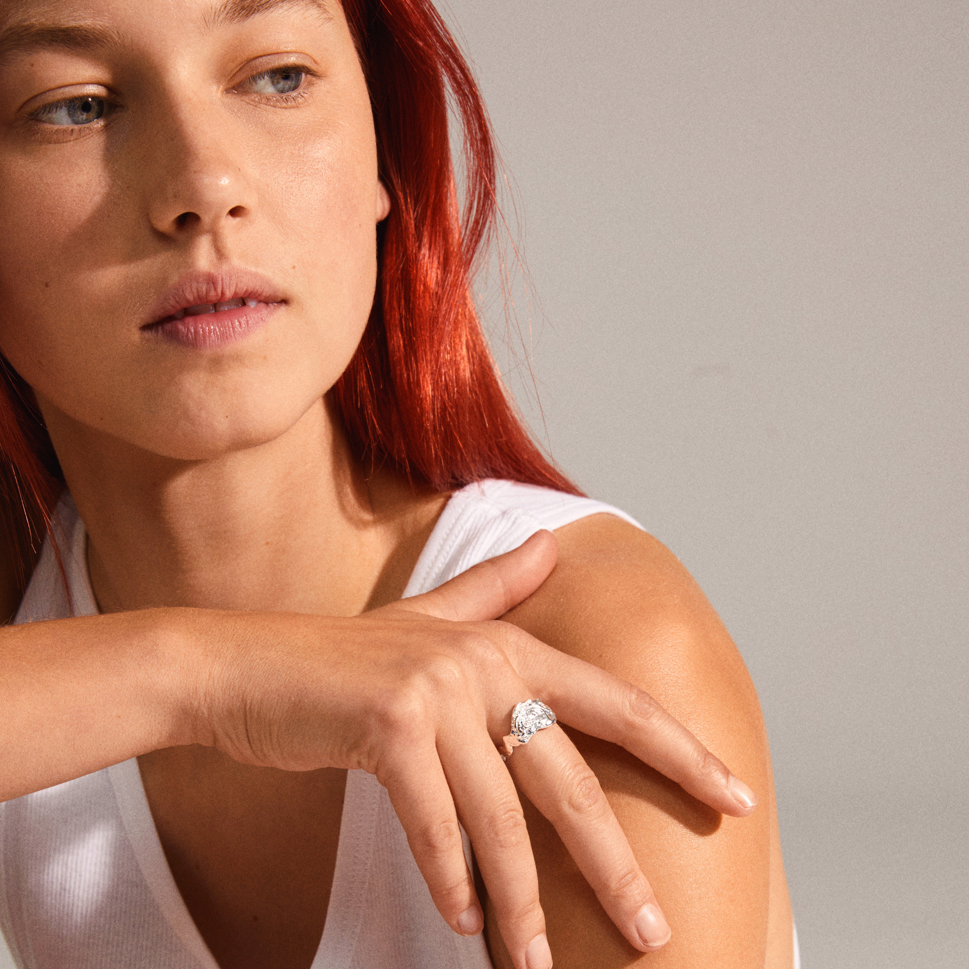 Woman wearing Pilgrim's BLOSSOM organic shaped silver-plated ring, showcasing its handcrafted, irregular design with unfinished edges and shiny surface.