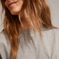 Woman smiling while wearing the ECHO pendant necklace, gold-plated, featuring a flower pendant with a central Preciosa crystal, 40 cm and 9 cm extension chain.
