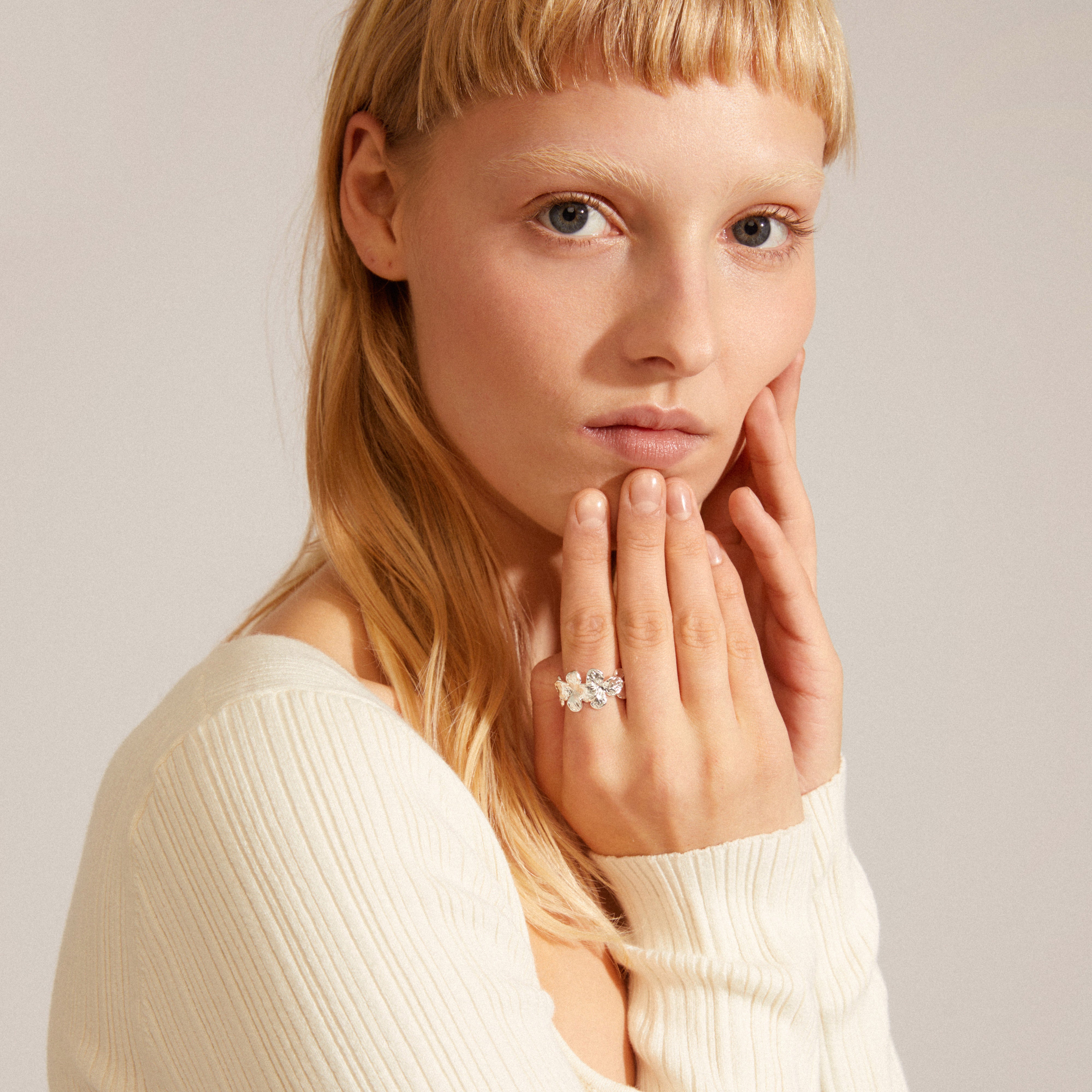ECHO ring silver-plated on woman's finger, showcasing Pilgrim's iconic floral design in a close-up, emphasizing natural beauty and timeless craftsmanship.
