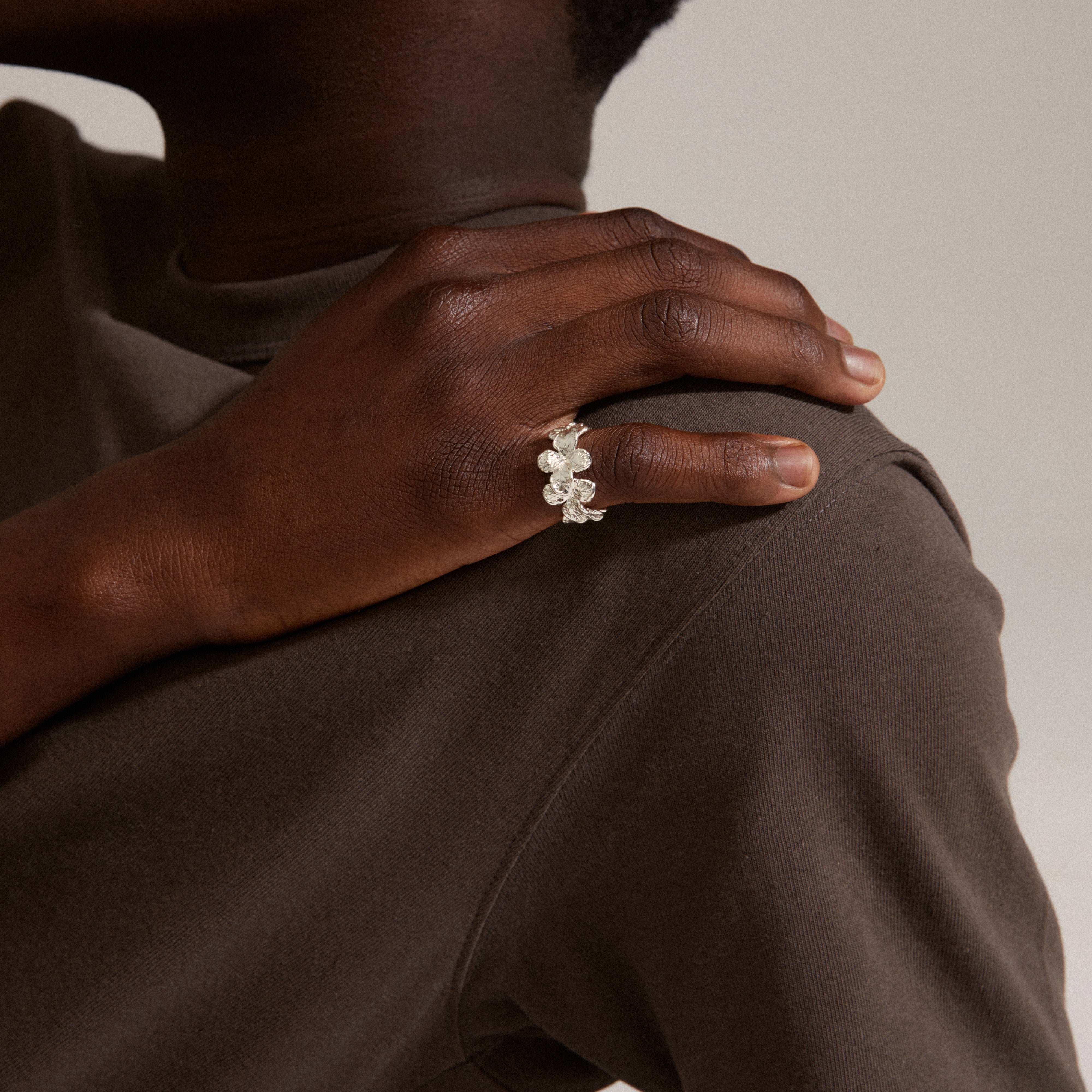 Close-up of a hand wearing the ECHO ring, a silver-plated floral design from Pilgrim, showcasing timeless natural beauty and sustainability.