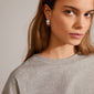 ECHO hoop earrings silver-plated showcased on a woman with long hair, featuring an iconic silver flower design, perfect for elevating a basic look.