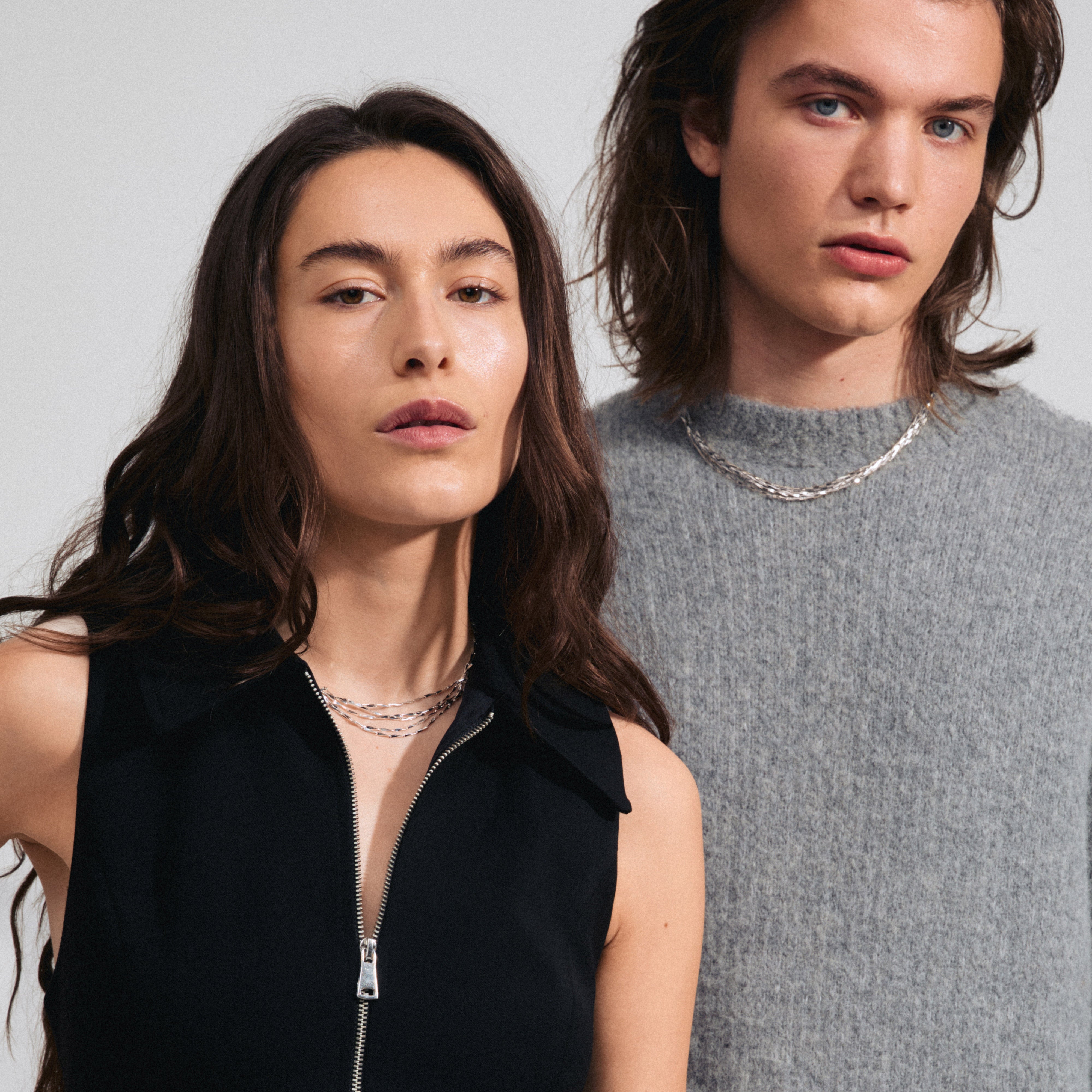 CONNECT necklace silver-plated by Pilgrim, featuring five layered chains with twisted melon seed links, worn by a woman. Captures trendy, light-catching design.