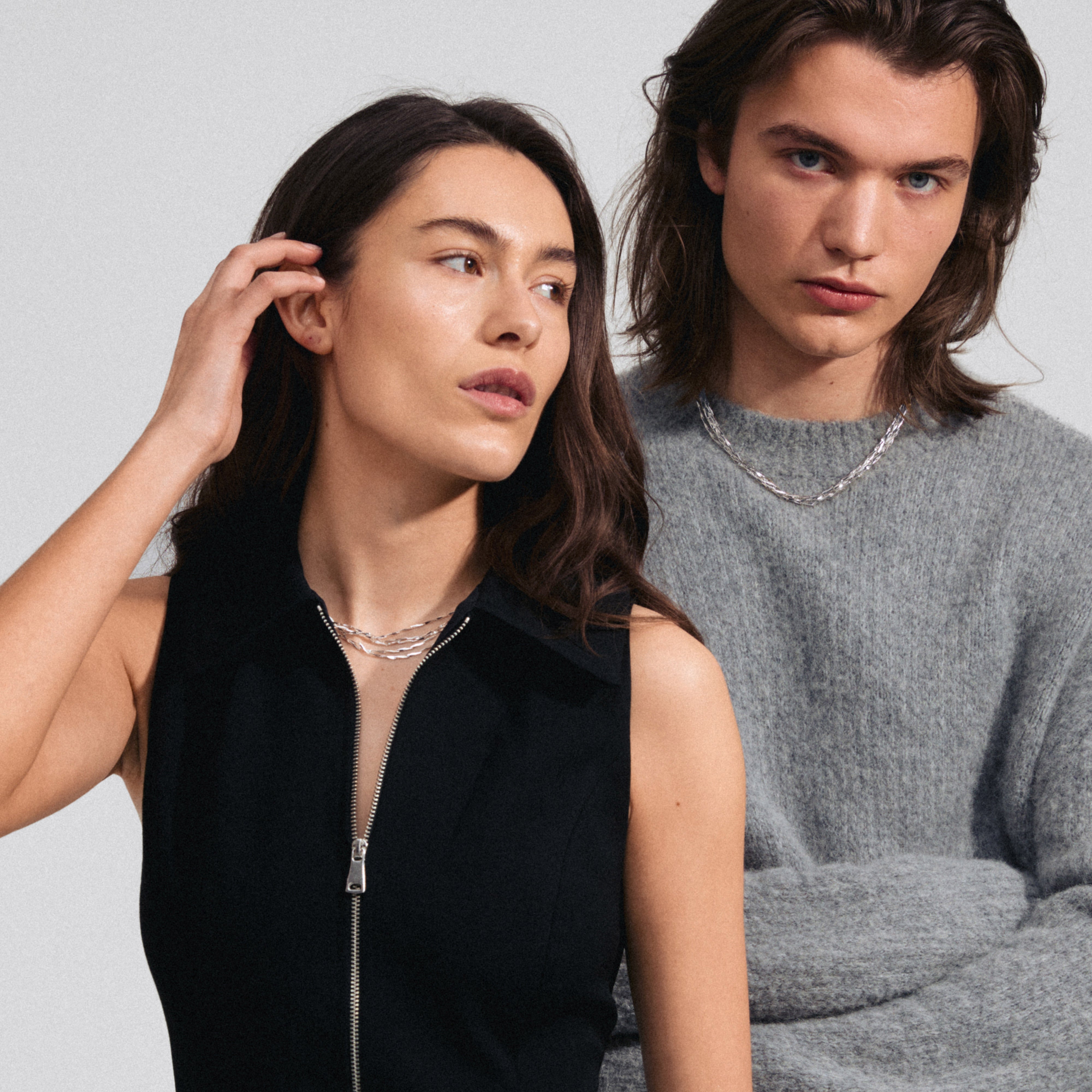 CONNECT necklace silver-plated, featuring five layered chains with twisted melon seed links, elegantly worn by a woman, showcasing its textured shine and sparkle.