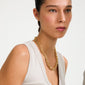 Close-up of a woman wearing Pilgrim's PHASE necklace, a gold-plated, chunky chain with a decorative lobster clasp, embodying urban chic and timeless style.
