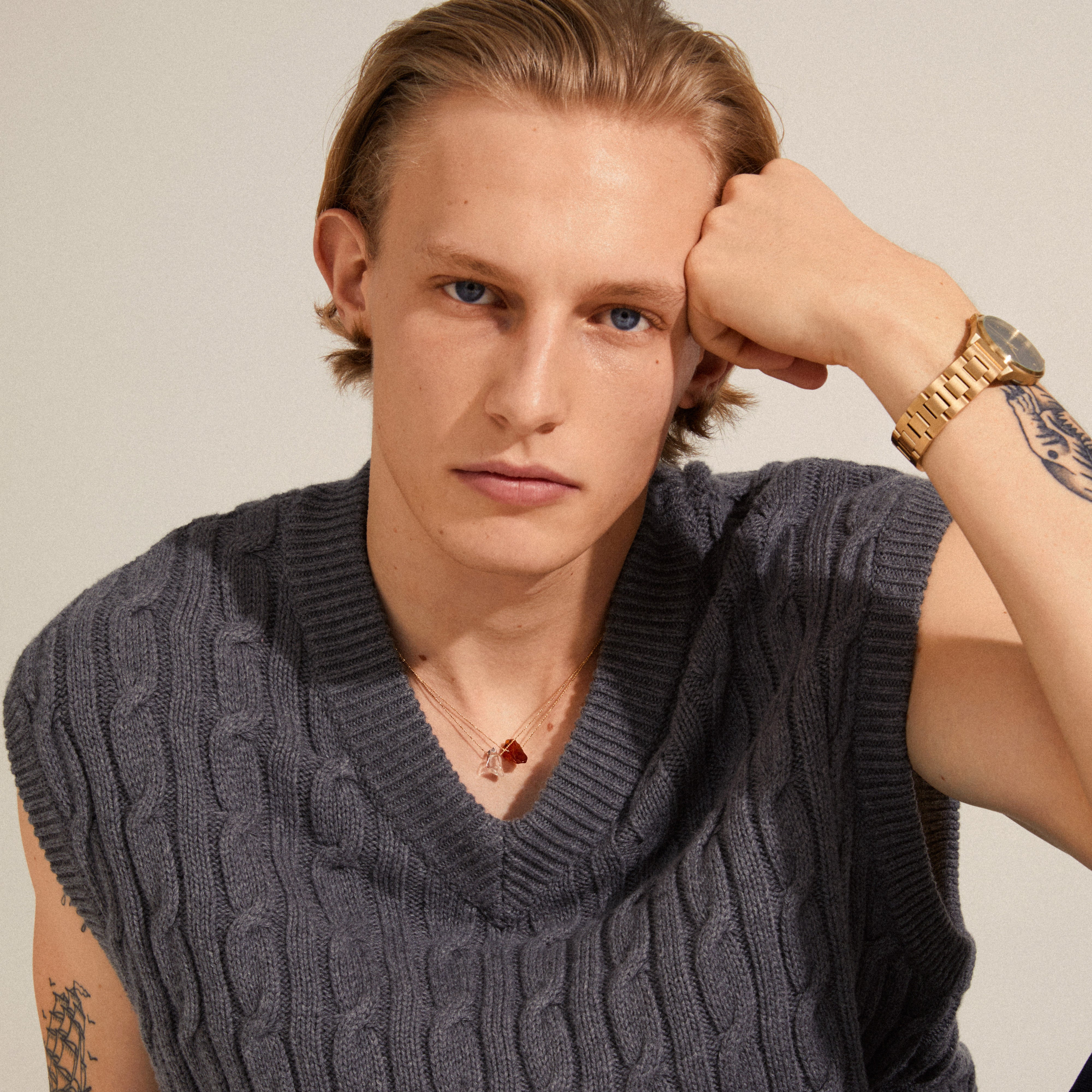 CHAKRA Carnelian necklace gold-plated featuring an orange carnelian pendant, worn by a tattooed man, showcasing Scandinavian craftsmanship and trendy design.