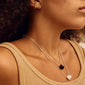 CHAKRA Black Agate necklace silver-plated, worn by a woman, featuring a black agate pendant on a silver chain, exudes grounding elegance.