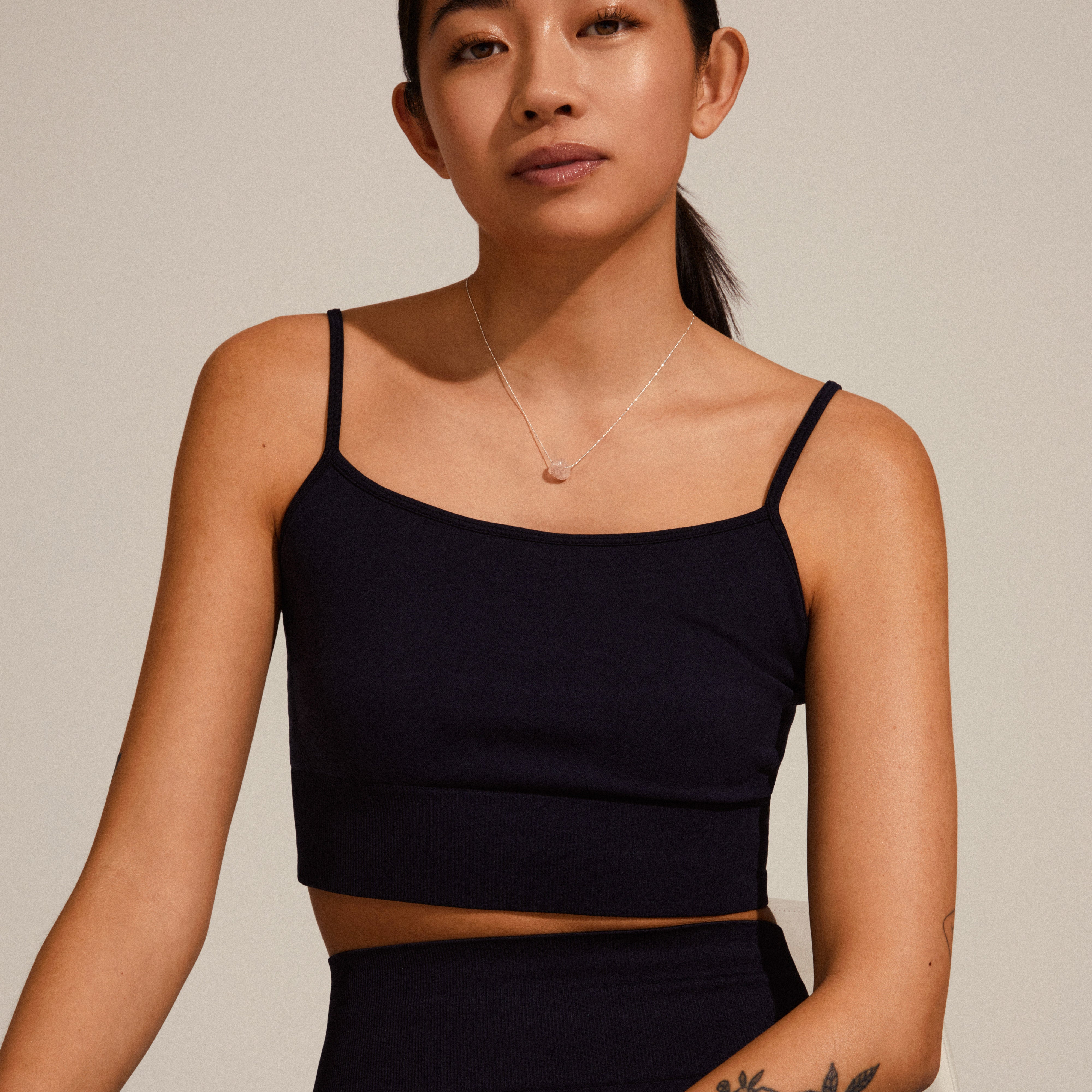 CHAKRA Rose Quartz necklace, silver-plated, displayed on a woman wearing a black top, highlighting the pendant's elegance and the chain's fit on the chest.