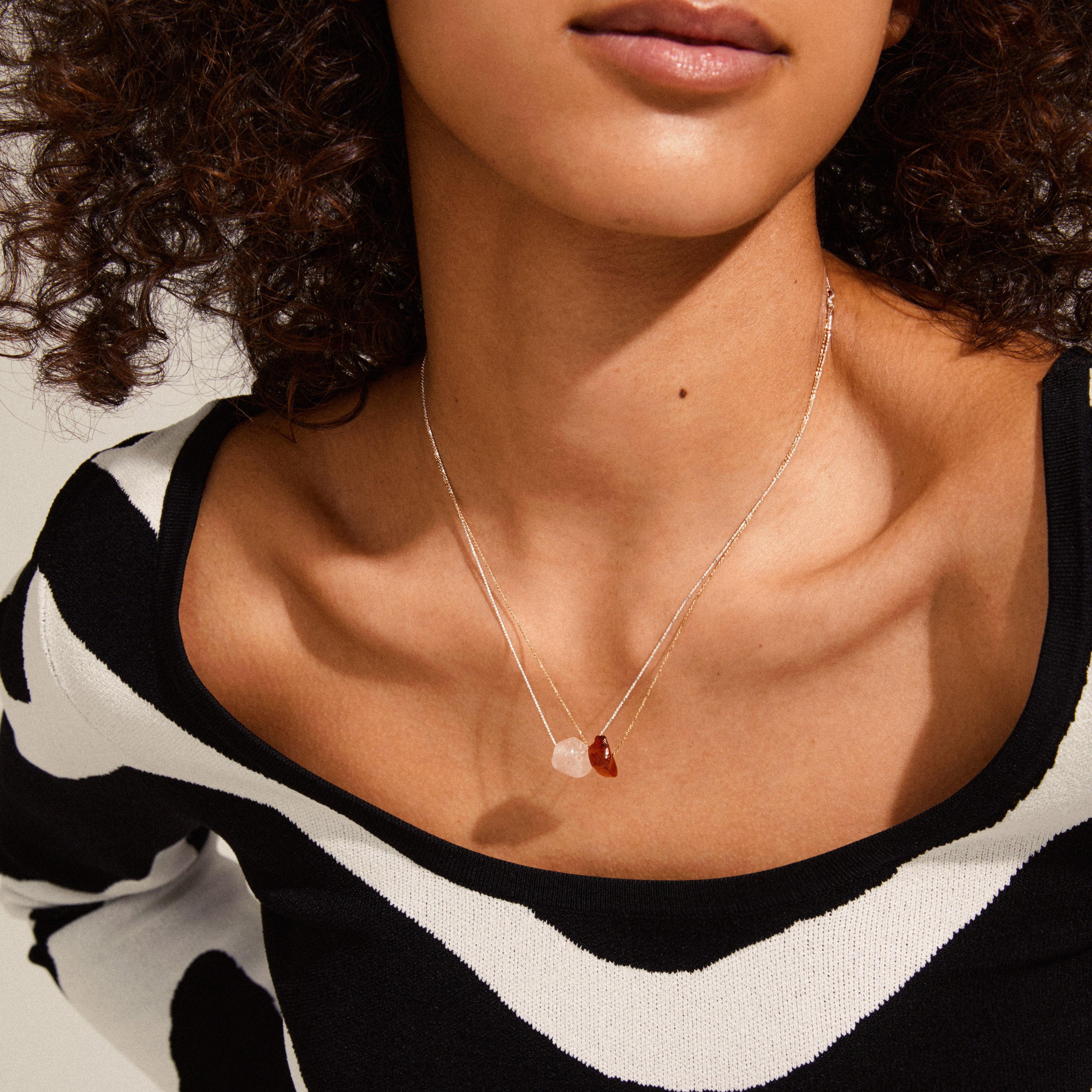 CHAKRA Rose Quartz necklace silver-plated worn by a woman, highlighting its pendant's natural beauty and elegant chain length.