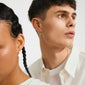 Two models showcase Pilgrim's DAGMAR huggie hoop earrings, gold-plated with floral motifs, highlighting Scandinavian craftsmanship and modern elegance in a clean, minimal style.