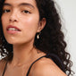 Gold-plated BREEZE hoops featuring conch shell pendants, worn by a woman with curly hair and a black tank top, highlighting summer beach vibes.