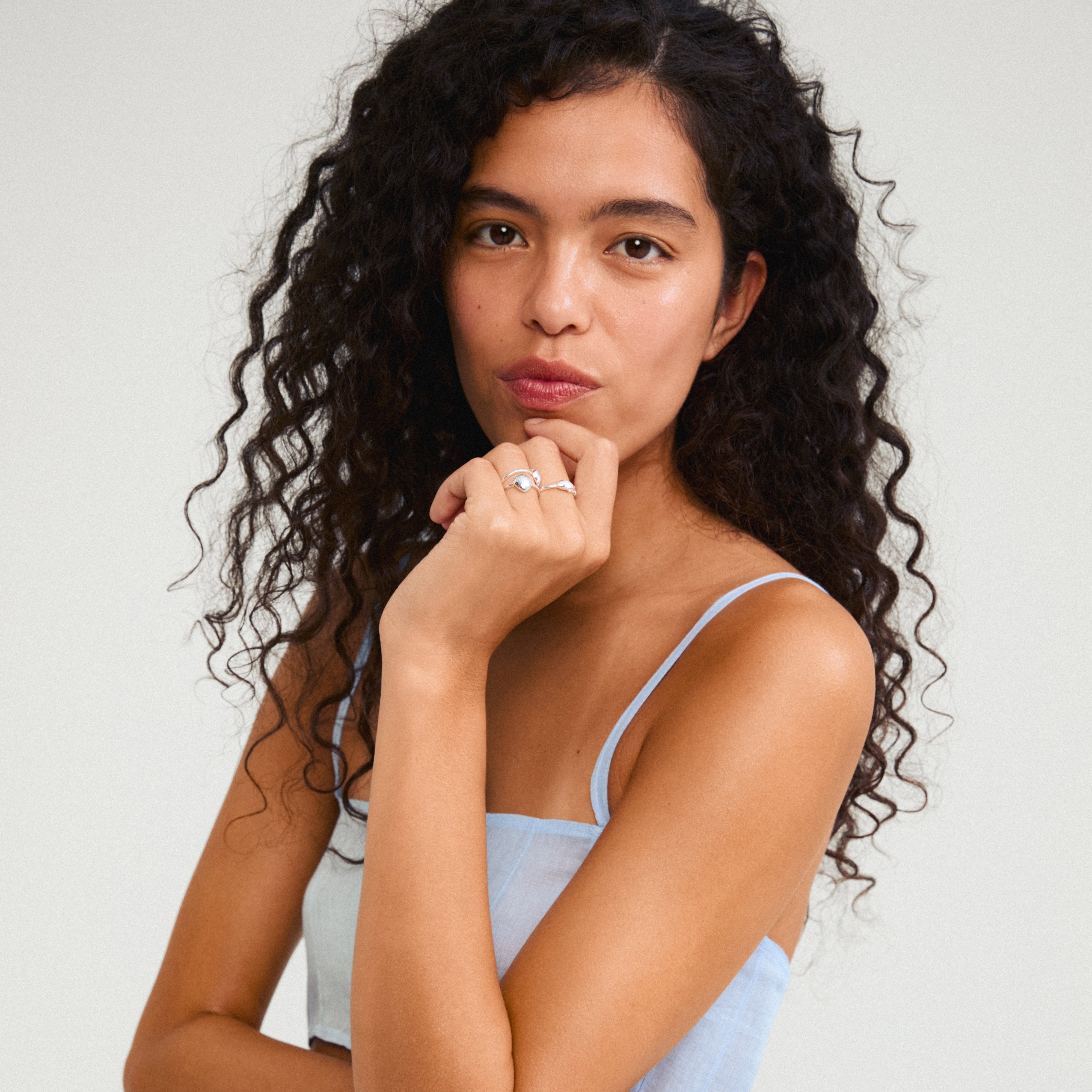 BREEZE rings 3-in-1 set silver-plated featuring seashell, conch, and fish charms on a woman's finger, embodying beachy vibes and sustainable style.