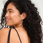 BREEZE chain earrings silver-plated, featuring asymmetrical chains with silver pendants and freshwater pearls, worn by a smiling woman with long curly hair.