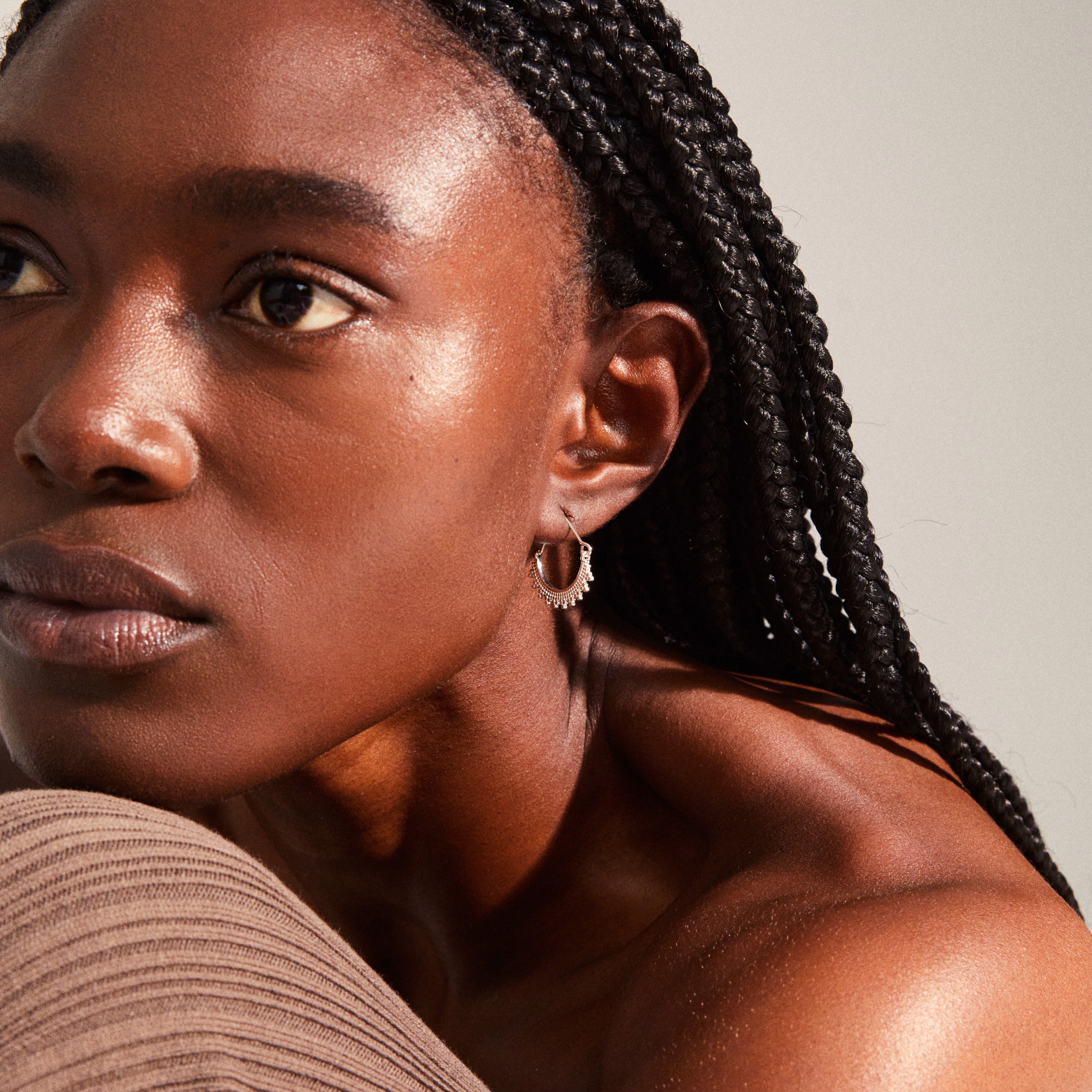 Silver-plated KIKU half hoop earrings with Asian-inspired patterns, worn by a woman with braided hair, showcasing their bohemian elegance and intricate design.