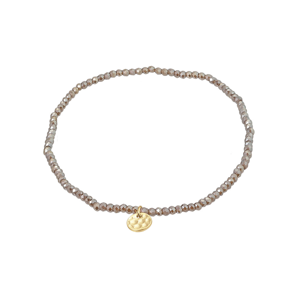 INDIE bracelet grey, gold-plated, featuring small faceted glass beads and a discreet gold disc, strung on durable elastic, perfect for a personalized, trendy look.