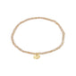INDIE bracelet in peach with gold-plated charm, featuring faceted glass beads and elastic fit, embodies Pilgrim's blend of timeless style and modern trend.