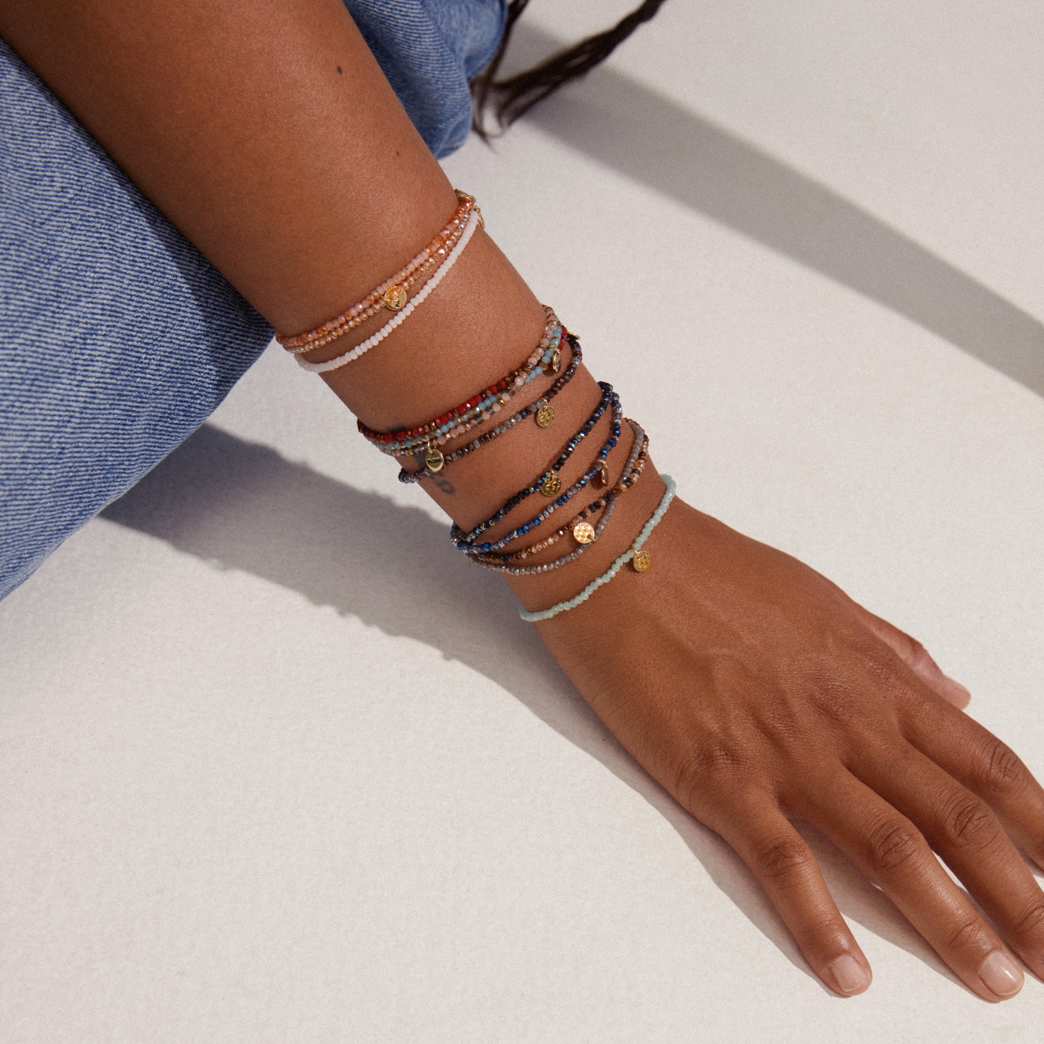 INDIE bracelet in purple with faceted glass beads and a discreet gold-plated Pilgrim logo on a wrist, showcasing its stylish, elastic design.