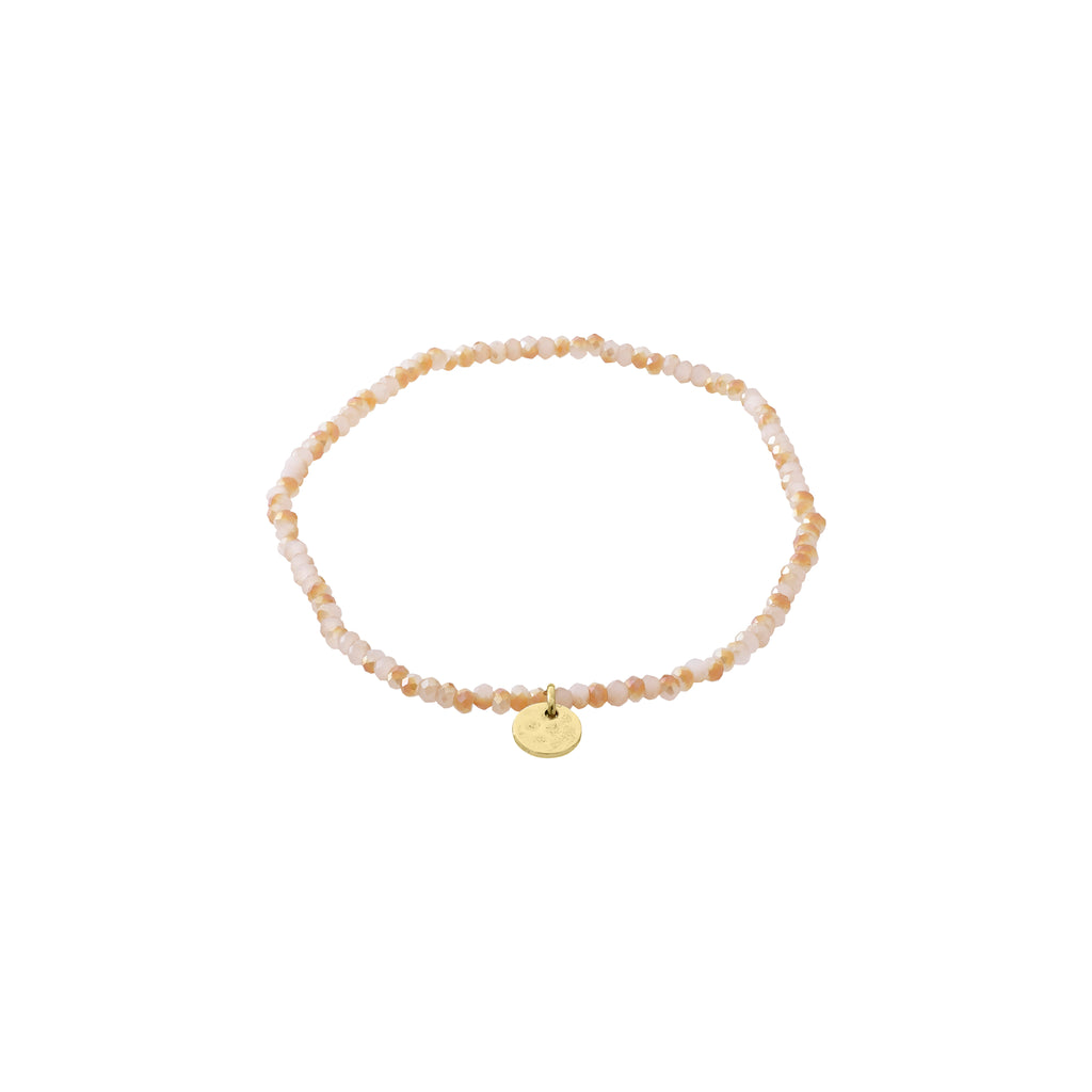 INDIE bracelet rose, gold-plated, featuring faceted light rose beads and a discreet gold disc charm, crafted with durable Lycra elastic for a comfortable fit.