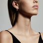 Woman wearing MACIE silver-plated earrings, showcasing elegant hoops as a chic fashion statement.