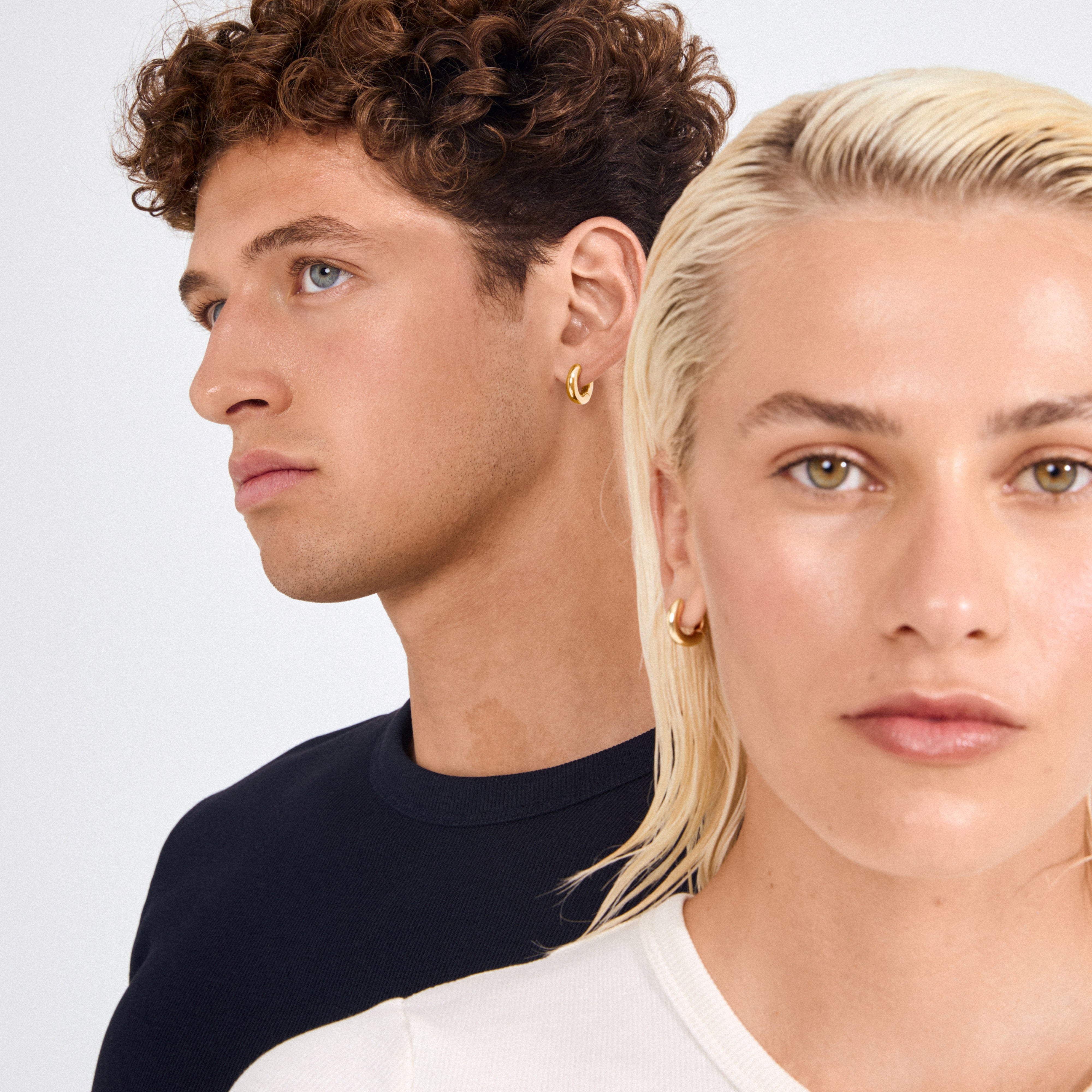 Two people wearing Pilgrim's AICA chunky gold-plated huggie hoop earrings, showcasing their bold, polished design ideal for everyday style.
