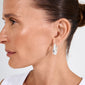 Profile view of a woman wearing Pilgrim's AUTUMN chunky retro hoop earrings, featuring bold, silver-plated teardrop design, adding a classy, vintage-inspired touch.