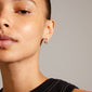 Close-up of a woman's ear showcasing MATYLDA silver-plated crystal hoop earrings from Pilgrim, highlighting their chunky silhouette and sparkling Preciosa crystals.