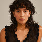 NADINE gold-plated earrings displayed on a woman with curly hair, showcasing their trendy ear crawler effect and shiny finish with tiny Preciosa crystals.
