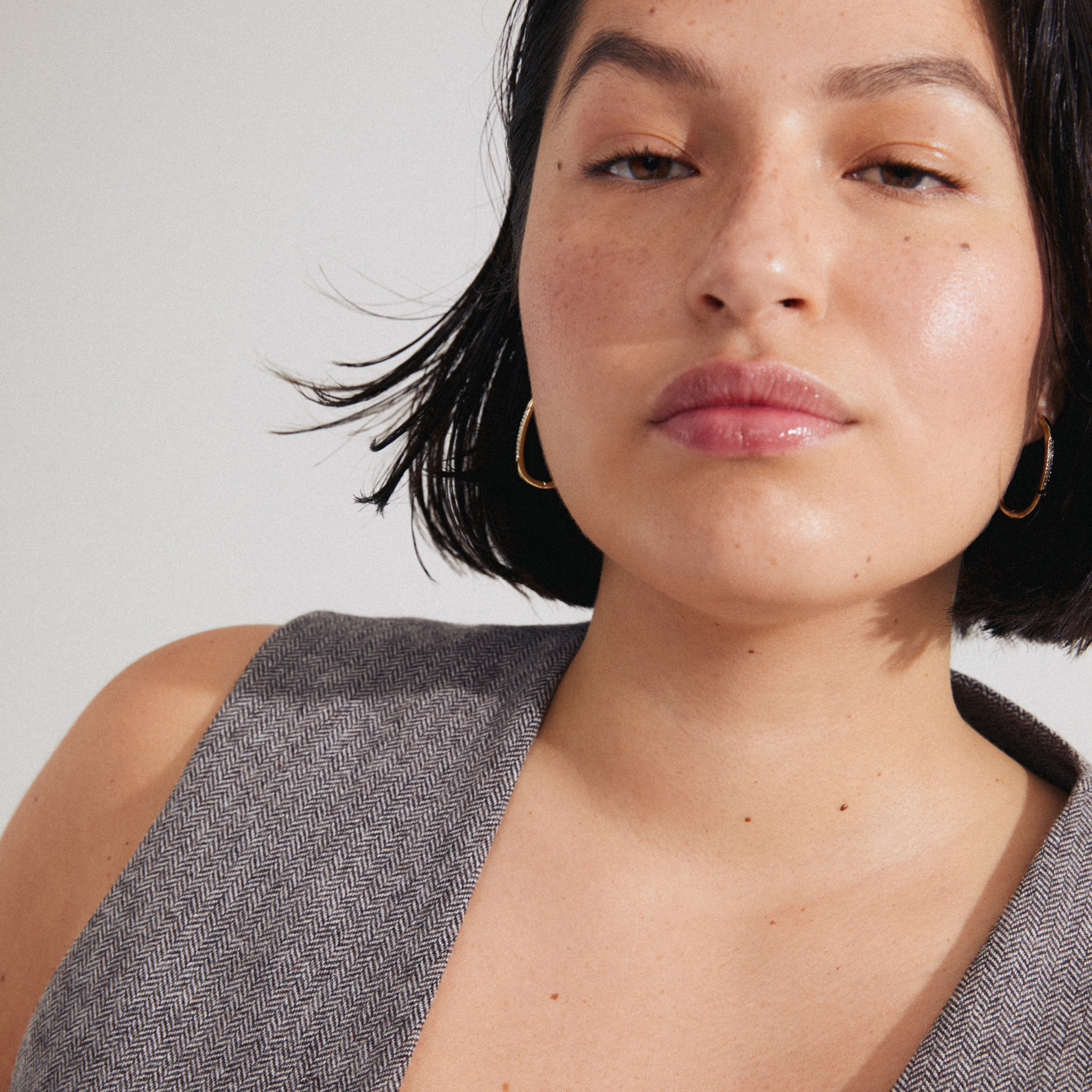 Woman wearing STAR gold-plated hoops from Pilgrim, featuring an elegant oval shape with Preciosa crystals, showcasing a stylish, modern look.
