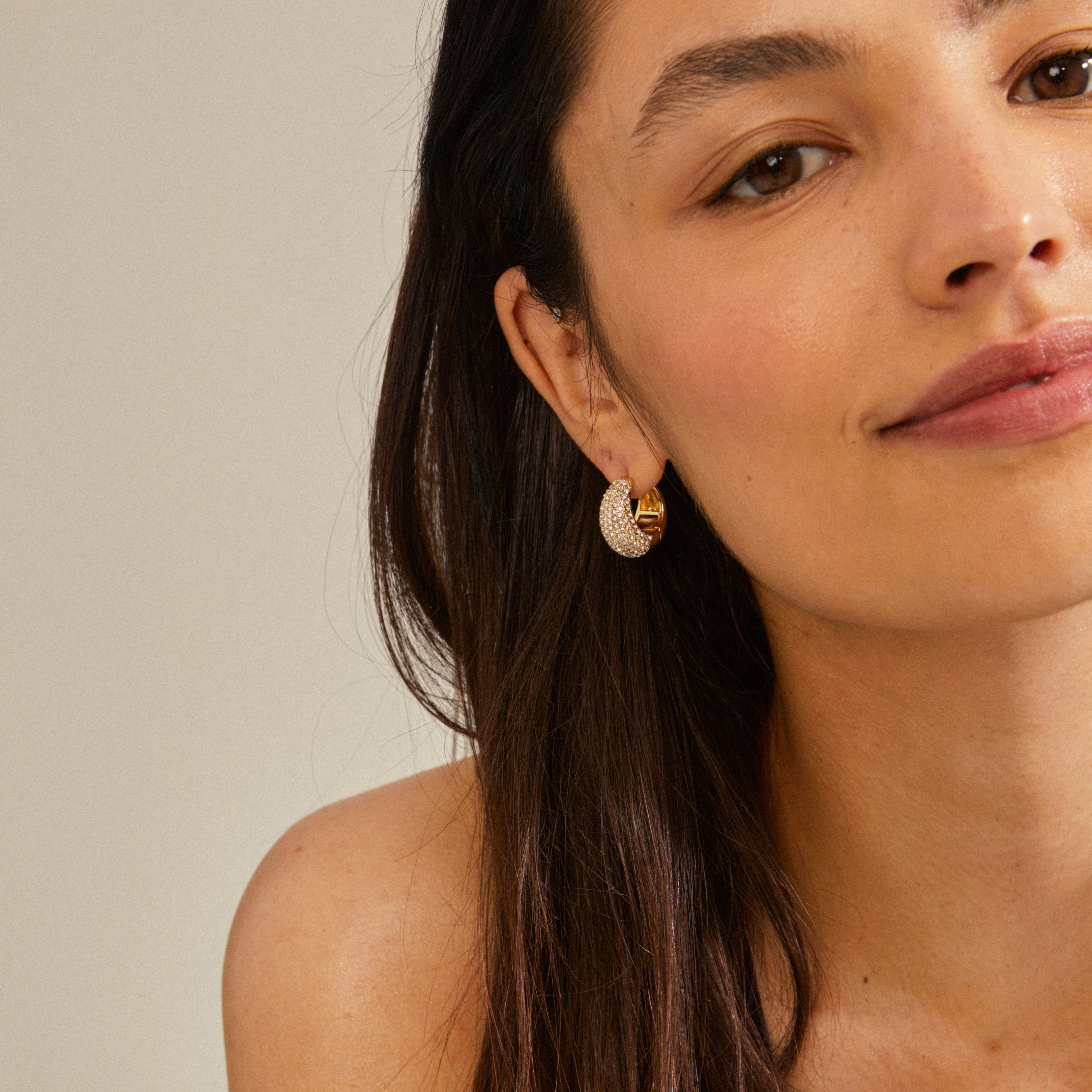 Close-up of a woman wearing NAOMI crystal hoops gold-plated, showcasing the chunky, sparkling design with Preciosa crystals from Pilgrim.