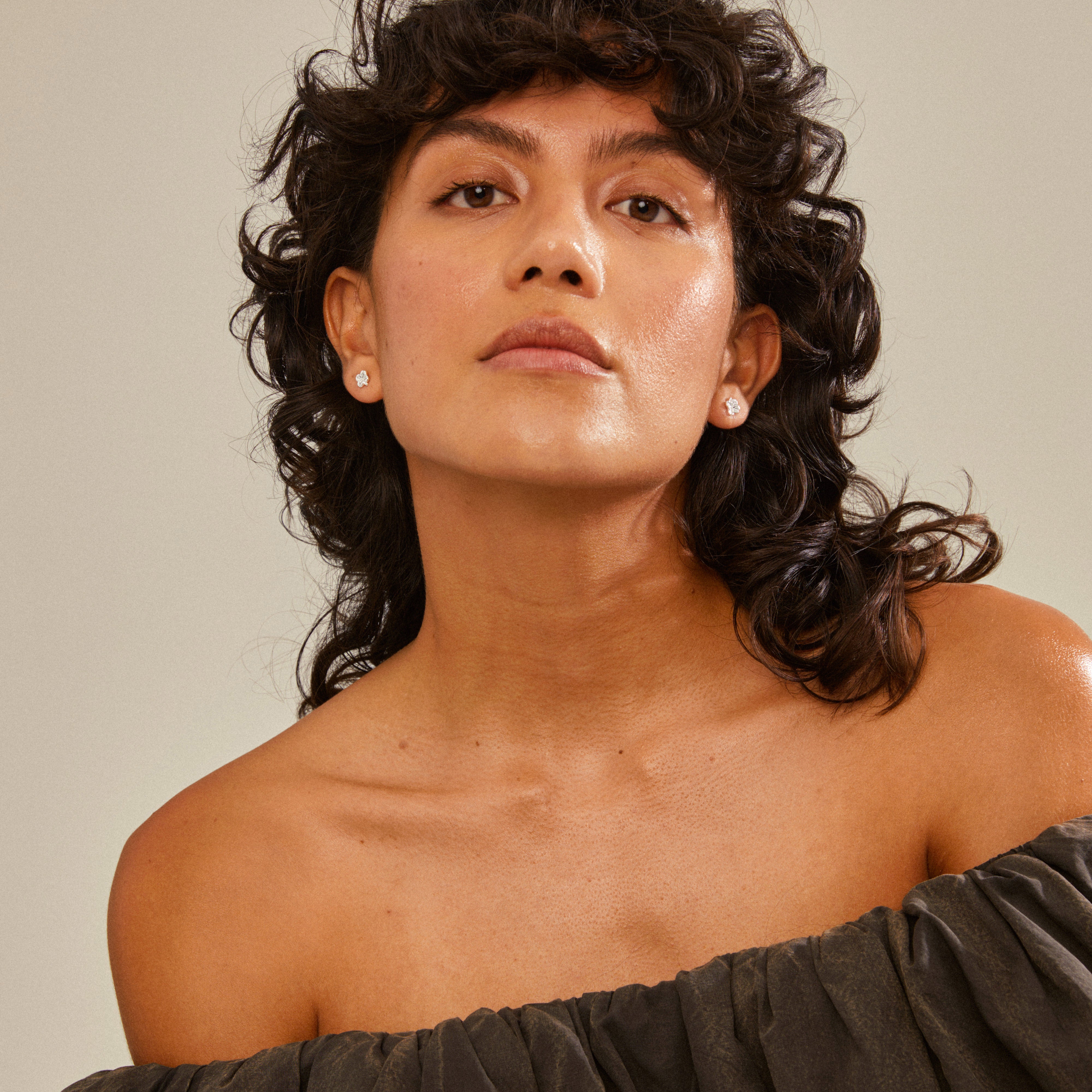 OCTAVIA clover earrings, silver-plated, worn by a woman with curly hair; symbolize luck and positivity; perfect for trendy ear curation.