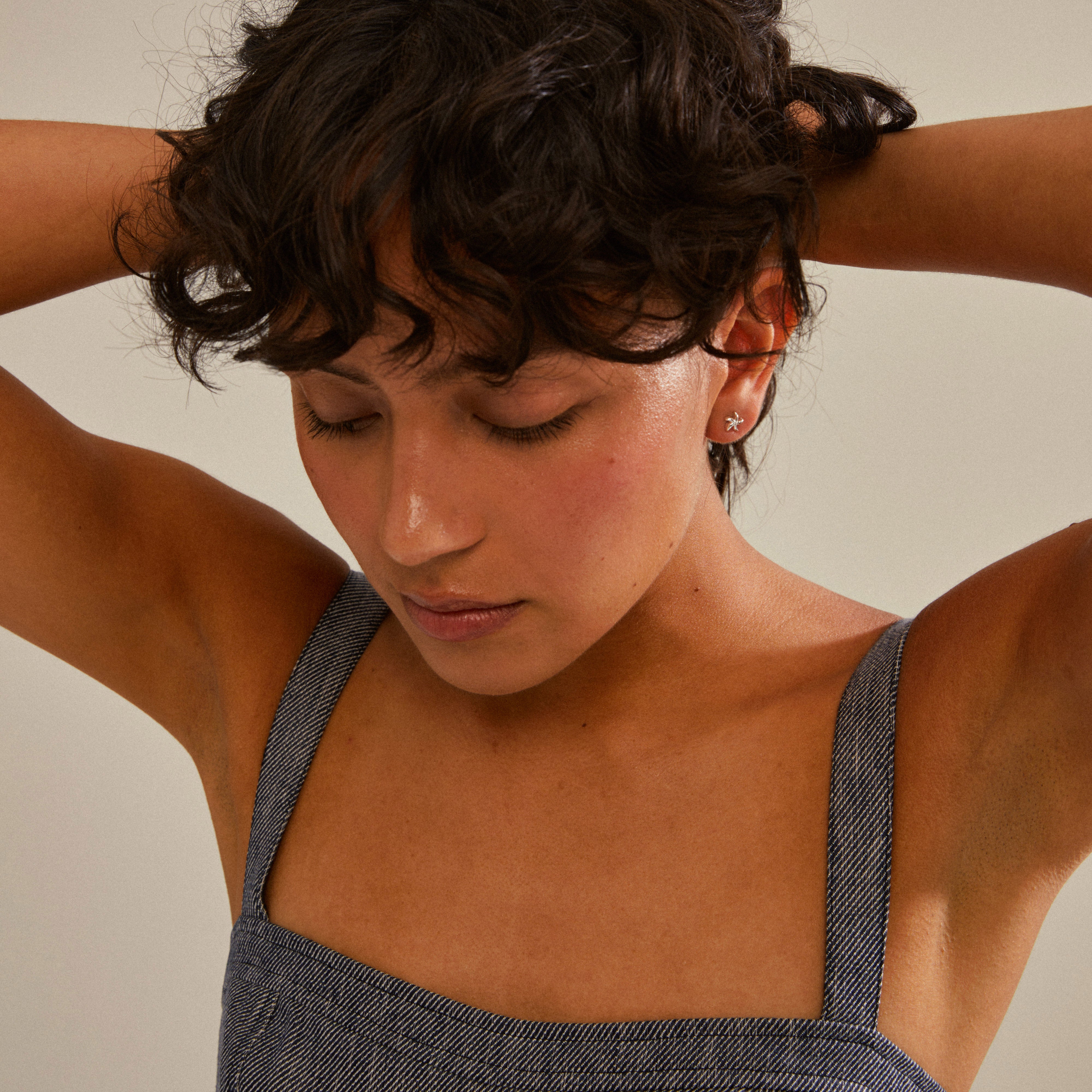 Woman wears OAKLEY starfish earrings, silver-plated, showcasing a trendy, ocean-inspired design. Ideal for mixing and matching, embodying Scandinavian craftsmanship and style.