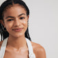 Woman wearing Pilgrim's ALISON gold-plated hoop earrings with earthy glass beads, showcasing a natural bohemian style, smiling directly at the camera.