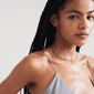 Woman with braids wearing the ALISON necklace, a blue, silver-plated piece from Pilgrim, styled for a relaxed, festival-inspired look.